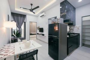 a kitchen and living room with a black refrigerator at Mini House Gombak 2BR 5pax Ayuman Suites in Kuala Lumpur