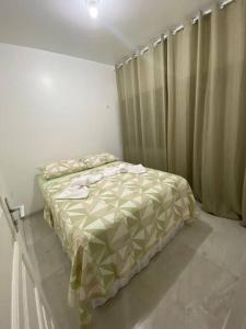 um quarto com uma cama e uma janela com cortinas em APARTAMENTO EM LOCAL PRIVILEGIADO em Maceió