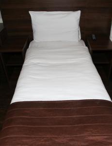 a bed with a white comforter and pillows at Ascot Hyde Park Hotel in London