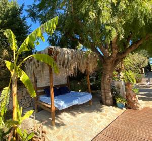 a bed under a tree with a thatch roof at Hotel Altea Paradise 1917 - Adults Only in Altea