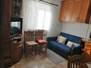 a living room with a blue couch and a tv at Governo's House in Melo