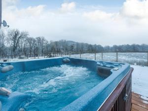 a jacuzzi tub with snow on the ground at Ty Afal - Uk42099 in Carno