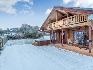 a log cabin with a deck in the snow at Ty Afal - Uk42099 in Carno