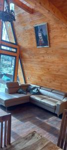 a living room with a couch in a wooden wall at Cabana Corbilor The Raven's Hut in Vatra Dornei