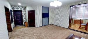 een lege woonkamer met twee deuren en een tafel bij Flagman apartment в центре города in Tasjkent