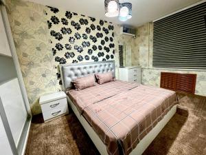 een slaapkamer met een bed met een roze dekbed bij Flagman apartment в центре города in Tasjkent
