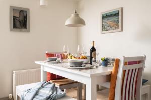 a white table with a bowl of fruit and wine glasses at Sundeck in Brixham