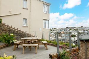 a patio with a table and benches on top of a building at Sundeck in Brixham