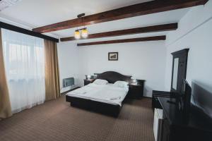 a bedroom with a bed and a flat screen tv at Pensiunea Casa Pescarilor in Sulina