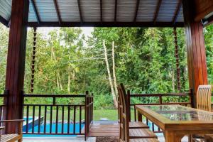 a screened in porch with a table and chairs at Villa Green Ice in Galle