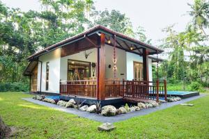 a small house with a large deck in a yard at Villa Green Ice in Galle