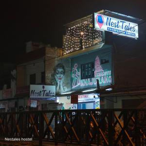 budynek z neonami na nim w nocy w obiekcie Nest Tales Backpacker Hostel w mieście Khajuraho