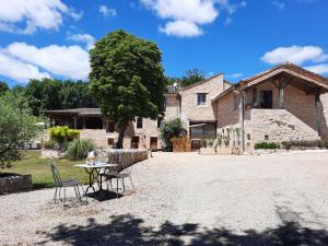 a table and chairs in front of a house at Le lodge de La Boissière in Andillac