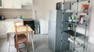 a kitchen with a table and a refrigerator at Maison à Orléans avec jardin in Orléans