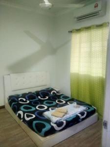 Beaufort Paguyut Homestay في بوفورت: غرفة نوم بسرير لحاف اسود وبيض