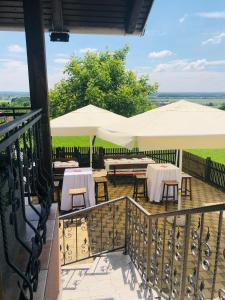 a patio with tables and umbrellas on a balcony at Kuća za odmor Mirna in Cepidlak