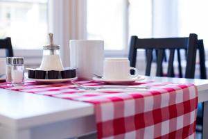 uma mesa com uma toalha de mesa xadrez vermelha e branca em Jungfrau Hotel Annex Alpine-Inn em Wilderswil