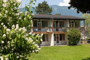 ein Haus mit weißen Blumen davor in der Unterkunft Jungfrau Hotel Annex Alpine-Inn in Wilderswil