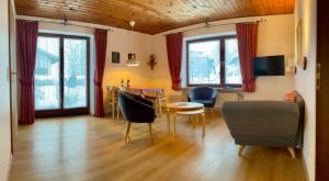 a living room with a couch and a table and chairs at Ferienwohnung Gästehaus Am Buchenbichl in Schönau am Königssee