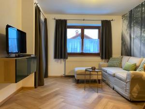 a living room with a couch and a tv at Landhaus Knaus in Leutasch