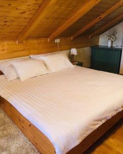 Cama grande en habitación con techo de madera en Kuća za odmor Mirna en Cepidlak