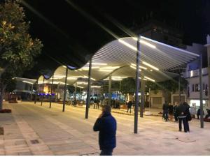 un grupo de personas de pie bajo un edificio por la noche en Bonito estudio, Torremolinos, COSTA DEL SOL, en Torremolinos