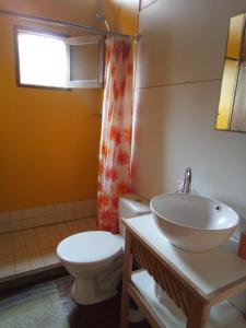 a bathroom with a sink and a toilet and a window at La Casita del Puente in La Pedrera