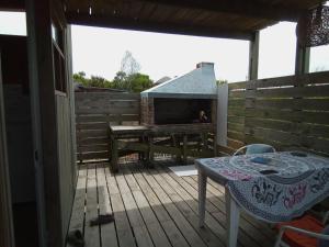 a wooden deck with a table and a fireplace at La Casita del Puente in La Pedrera