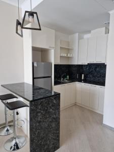 een keuken met witte kasten en een zwart aanrecht bij Alvina apartment Tsaghkadzor in Tsachkadzor