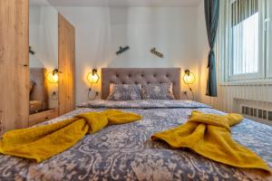 Un dormitorio con una cama grande con mantas amarillas. en Apartman Relja Zlatibor, en Zlatibor