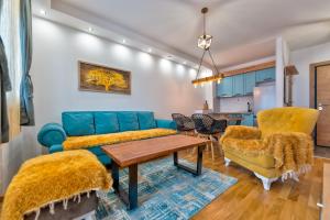Una sala de estar con un sofá azul y sillas. en Apartman Relja Zlatibor, en Zlatibor