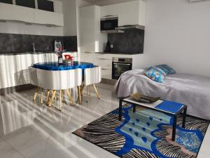 ein Wohnzimmer mit einem Bett und eine blau-weiße Küche in der Unterkunft Villa HARMONY in Vallauris