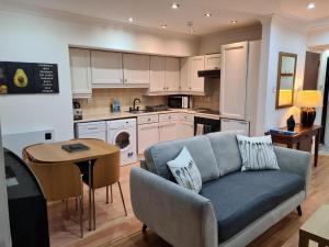 4 New Assembly Close - Royal Mile في إدنبرة: غرفة معيشة مع أريكة ومطبخ