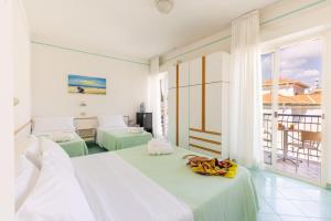 a hotel room with two beds and a balcony at Hotel Caprice - in centro a Riccione in Riccione