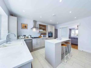 a kitchen with white cabinets and a white counter top at Broadstairs Beach Bungalow. Dogs welcome! in Broadstairs