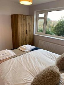 a bedroom with a large bed with a window at Broadstairs Beach Bungalow. Dogs welcome! in Broadstairs
