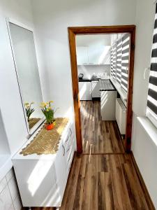 cocina con armarios blancos y suelo de madera en Apartament Willa Aurora, en Kudowa-Zdrój