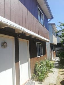 una casa marrón con una puerta de garaje blanca en Shofia3, en Valdivia