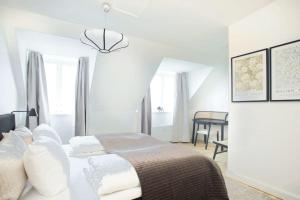 ein weißes Schlafzimmer mit einem Bett und einem Tisch in der Unterkunft Cozy 3BR Lake View Flat w Bath Tub in Copenhagen in Kopenhagen
