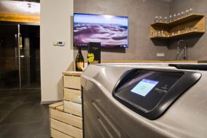 a bathroom with a sink with a tv on the wall at Apartmány a Wellness VMAL s.r.o. in Skuteč