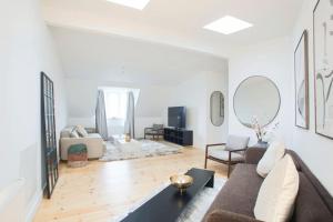 ein Wohnzimmer mit einem Sofa und einem Tisch in der Unterkunft Cozy 3BR Lake View Flat w Bath Tub in Copenhagen in Kopenhagen