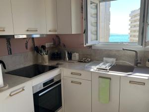 a kitchen with white cabinets and a sink and a window at Las Palmas in Marbella