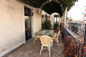 un patio con tavolo e sedie sul balcone. di Raciti Palace ad Acireale