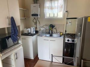 una pequeña cocina con fregadero y nevera. en Shofia3, en Valdivia
