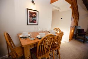 a dining room table with chairs and a wooden tableablish at Hayloft Cottage - Rudge Farm Cottages in Bridport +40 photos
