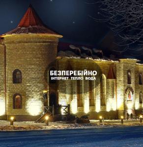 a large brick building with a sign on it at Готельно-ресторанний комплекс «Галицький замок» in Ternopilʼ