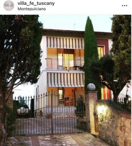 een huis met een hek ervoor bij Villa Fè -Choose Panoramic View, Jacuzzi, Private Parking in Montepulciano