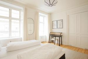 - une chambre blanche avec un lit et un miroir dans l'établissement Large & Bright 3BR Flat w Whirlpool Near Metro, à Copenhague