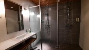 a bathroom with a sink and a shower with a mirror at Apartment Kelotahti in Saariselka