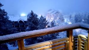 a snow covered yard with a fence and trees at Apartment Kelotahti in Saariselka